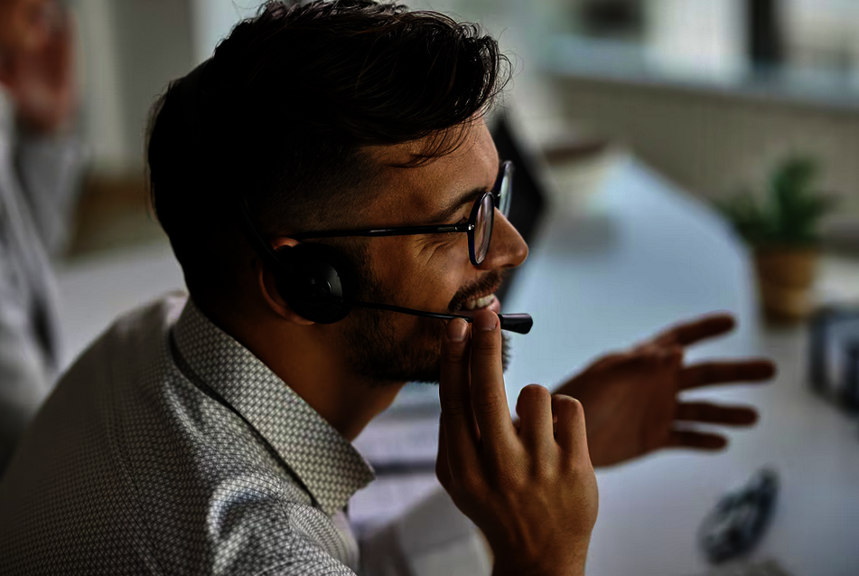 happy-call-center-agent-wearing-headset-while-talking-with-clients-working-office cold emailing and cold calling