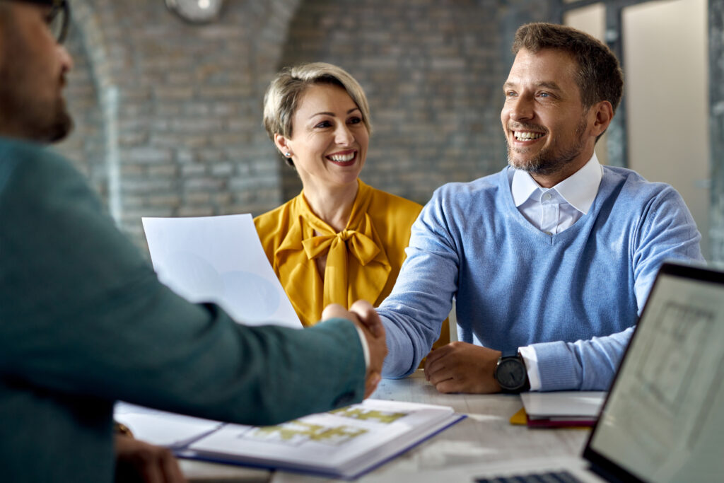 happy-couple-shaking-hands-with-real-estate-agent-after-successful-agreement-office-salespeople sales industry