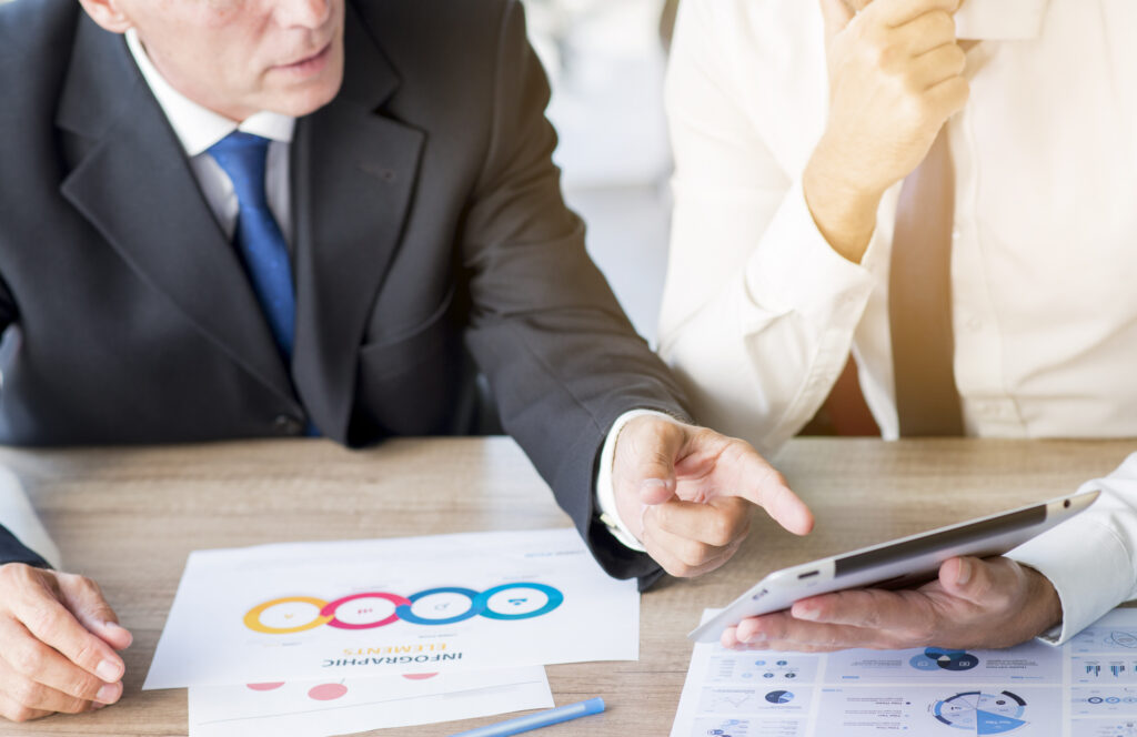 businessman-pointing-finger-digital-tablet-hold-by-his-partner-workplace