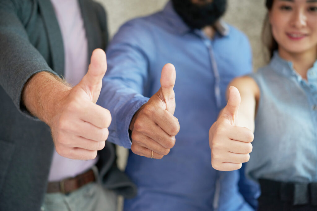 Close-up of business team showing thumbs up in the camera remote sales force