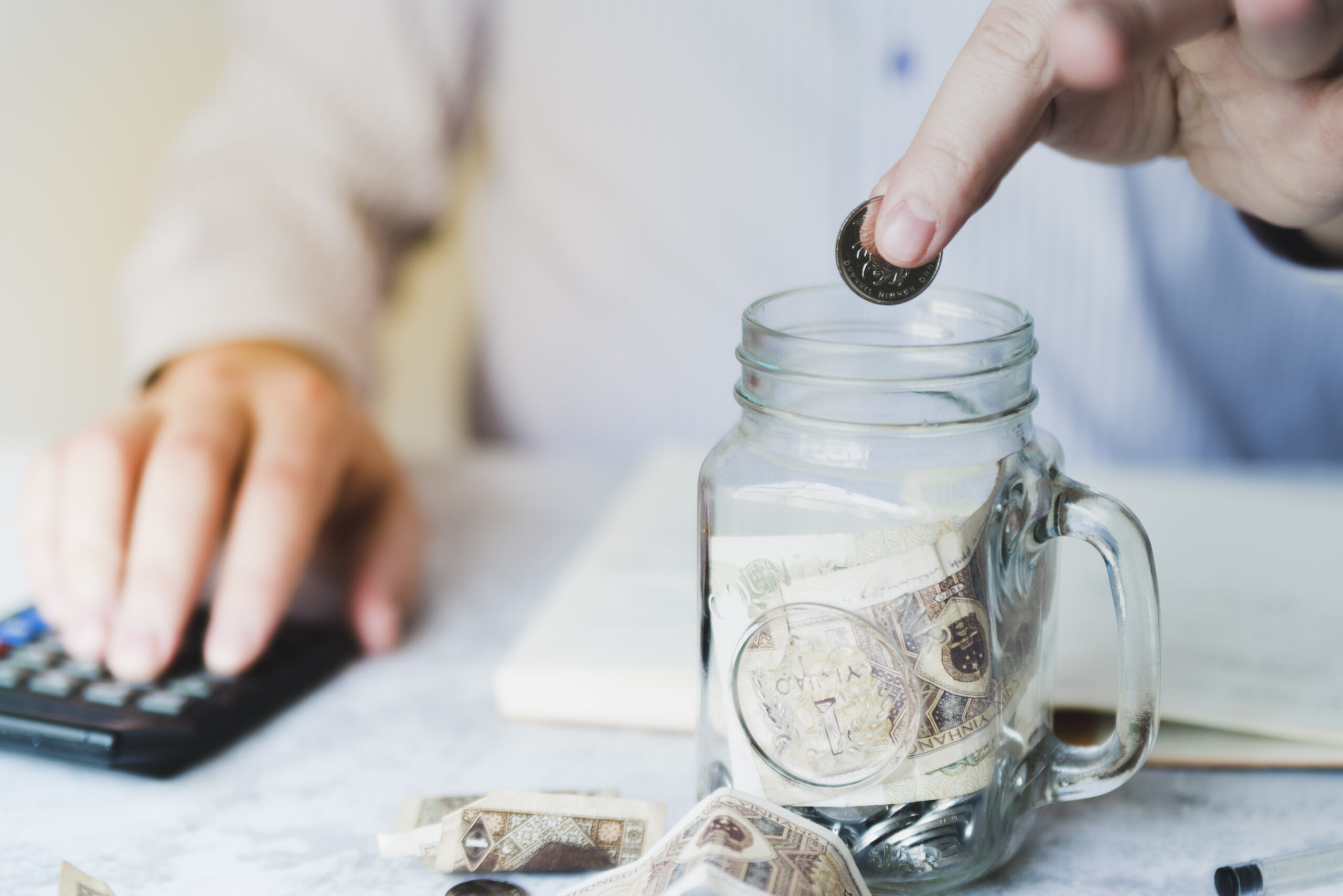 hand-putting-coin-inside-jar benefits of sales outsourcing